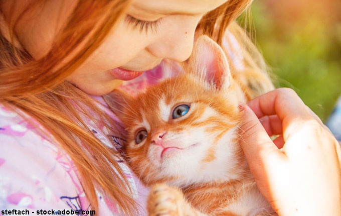 Mädchen kuschelt mit Kitten