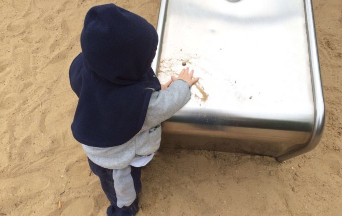 Spielplatz - Kind spielt an der Rutsche