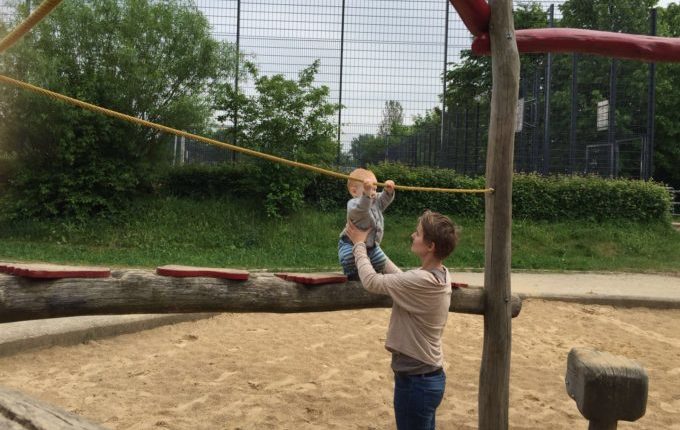 Spielplatz - Mutter hält Kind beim Balancieren