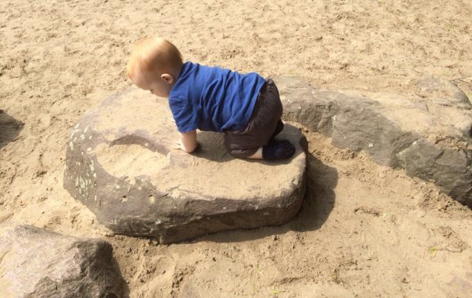 Spielplatz - Kind klettert auf Stein