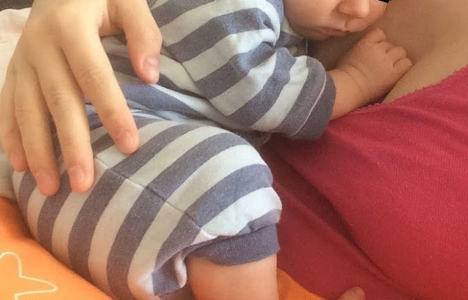 Baby schläft angekuschelt an Mama