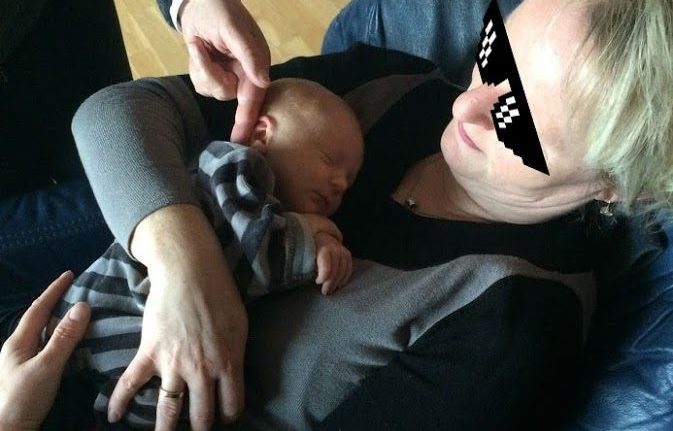 Frau hält schlafendes Baby in den Armen
