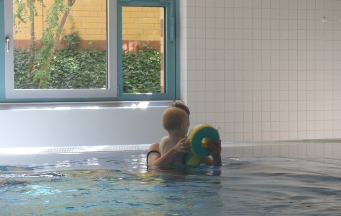 Babyschwimmen - 11. Tag - Mutter zieht Kind Schwimmflügel aus