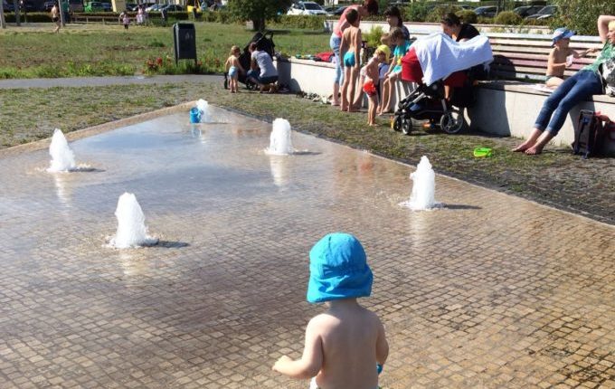 Springbrunnenplatz - Kind steht an einer Fontäne