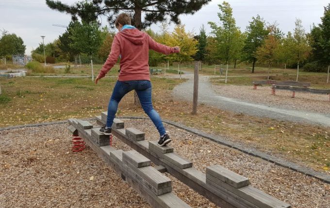 Der Buchstaben- und Balancierspielplatz in der Sebnitzer Straße - Frau balanciert breitbeinig