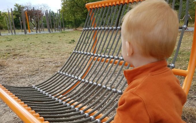 Der Buchstaben- und Balancierspielplatz in der Sebnitzer Straße - Kind an Seilsitz