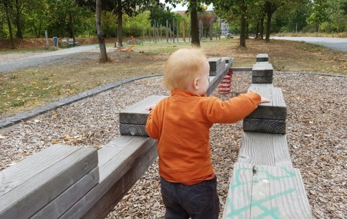 Der Buchstaben- und Balancierspielplatz in der Sebnitzer Straße - Kind läuft zwischen Balken