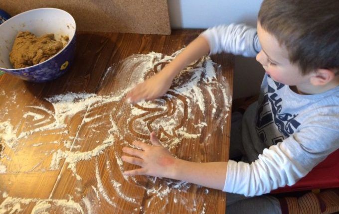 Lebkuchenhaus mit Sprungschanze - Kind malt im Mehl