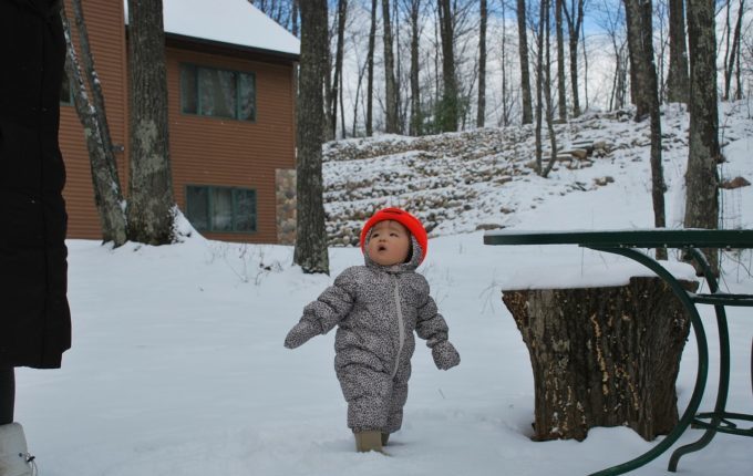 Kind mit roten Haaren kurzärmelig im Schnee
