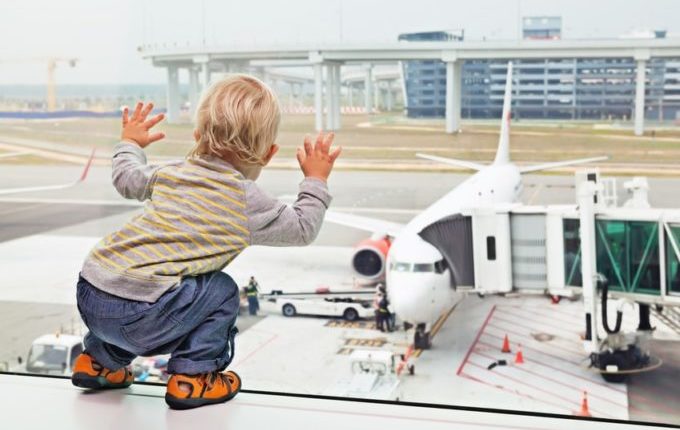 Fliegen mit Kindern - Kind schaut Flugzeuge an