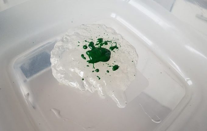 grüne Lebensmittelfarbe auf Flüssigkleber in Schüssel