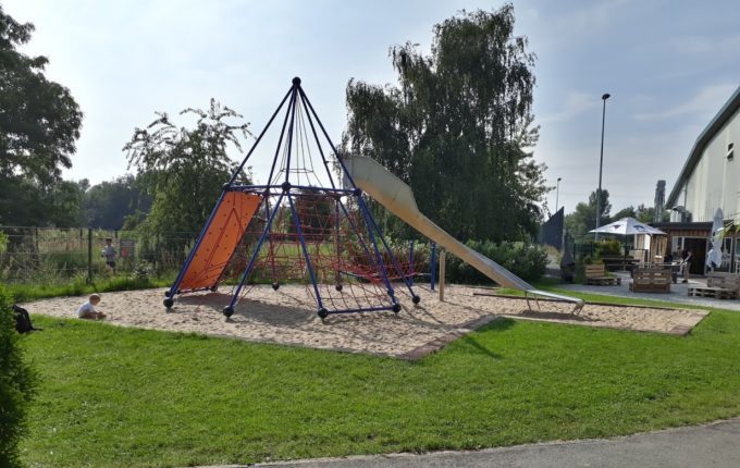 Tommys turbulente Tobewelt - Kind spielt im Sand neben Kletterspinne