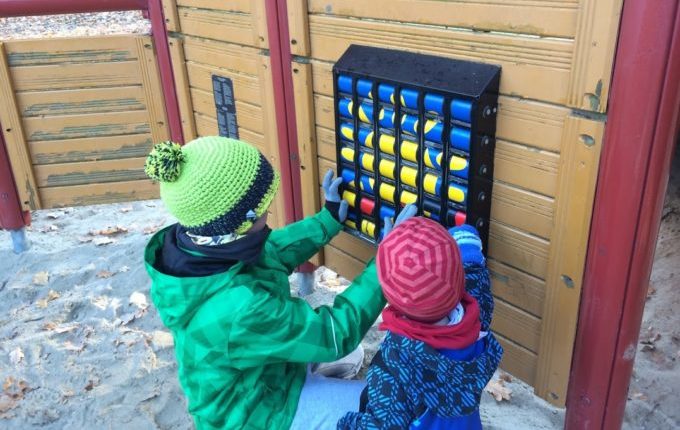 Kinder spielen im Winter auf dem Spielplatz