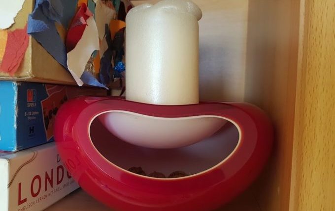weiße Kerze in roter Schale = Pilz