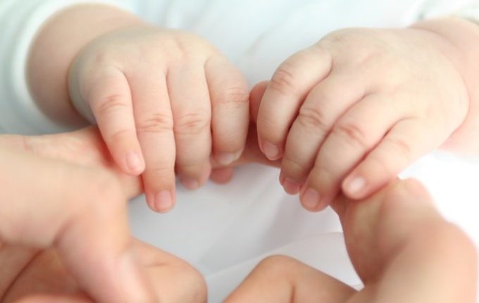 Babyhände halten große Hände