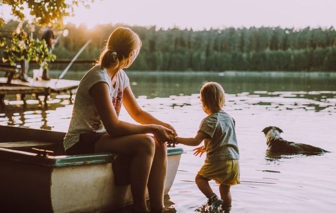 Mutter allein mit Kind und Hund am See