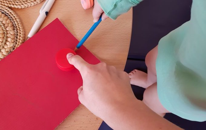 Kind umrandet Flaschendeckel mit Bleistift