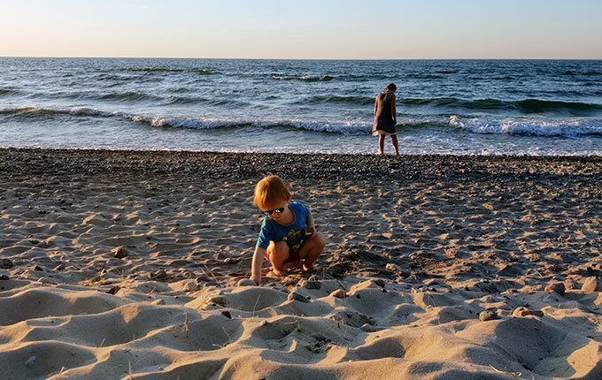 Kind sammelt Schätze am Strand