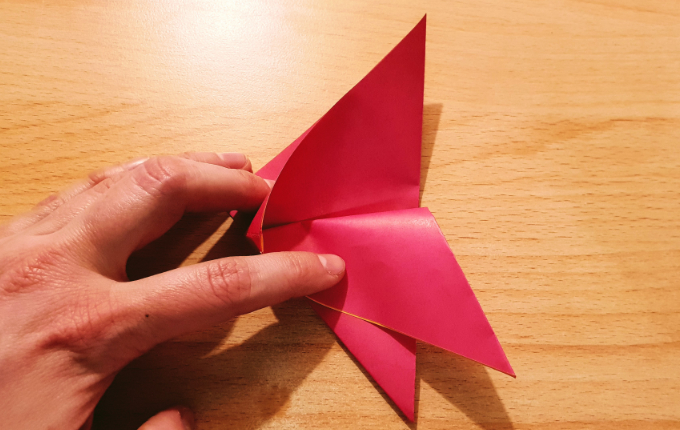 Hand faltet Origami Flügel vom Osterhuhn