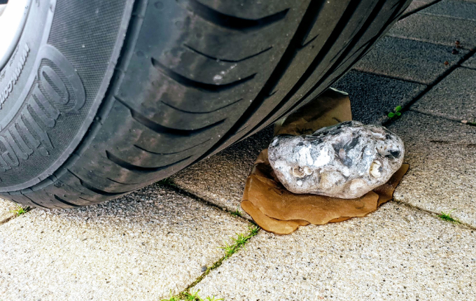 Hinweis mit Stein unter Auto für Schatzsuche