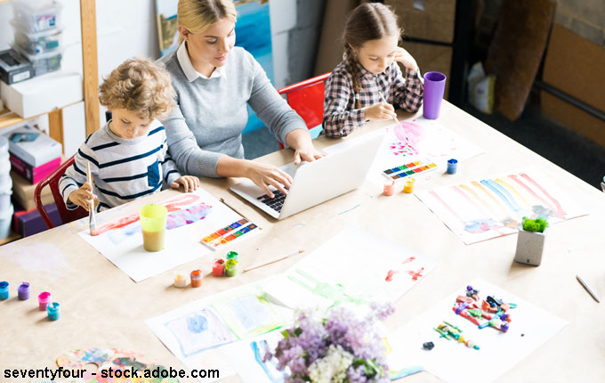 Mama am Laptop mit spielenden Kinder