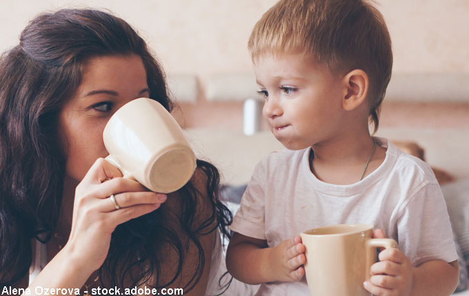 Mama trinkt Kakao mit Kind aus Tassen