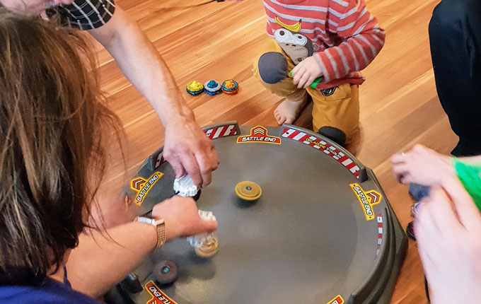 Kind spielt Beyblade mit Familie