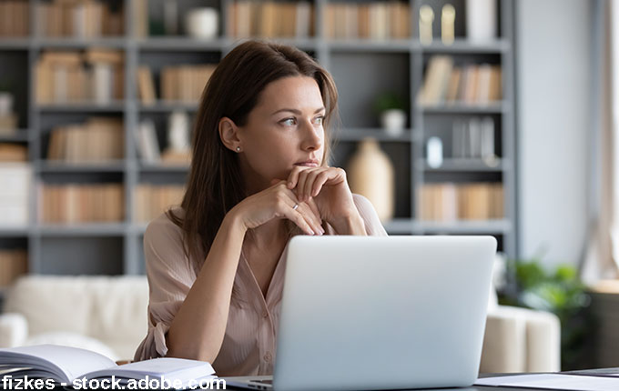 Frau nachdenklich vor Notebook